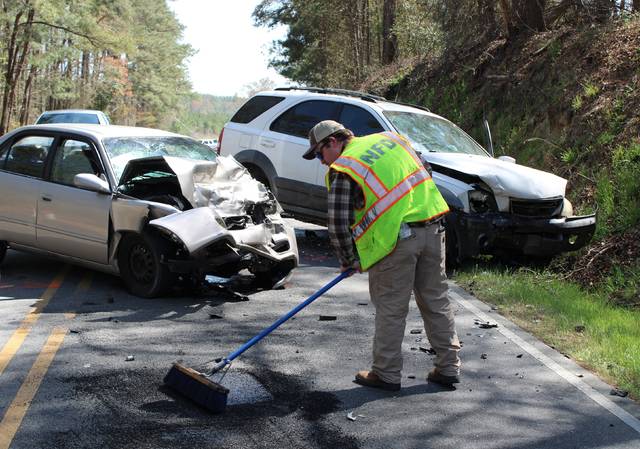 126752363_web1_Wreck3
Gavin Stone | Daily Journal
A Northside Volunteer Fire Department volunteer helps clean up Ledbetter Road after a wreck on Sunday.
