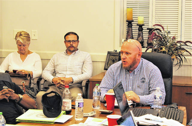 
			
				                                Gavin Stone | Daily Journal
                                Board of Commissioners Chair Jeff Smart, right, speaks while Hamlet City Manager Matthew Christian looks on, flanked to his right by Hamlet City Councilwoman Abbie Covington.
 
			
		