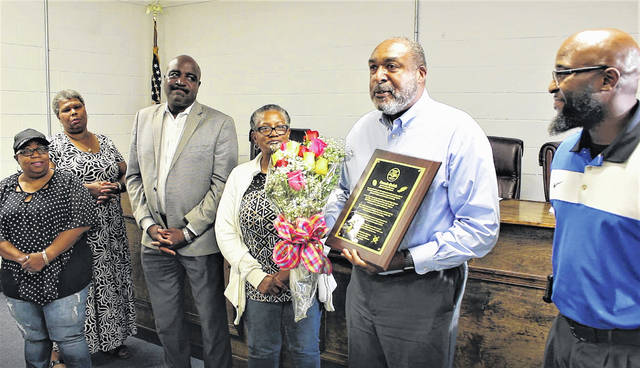 
			
				                                Gavin Stone | Daily Journal
                                Dennis Quick, center, accepts a plaque and bouquet of flowers from the Dobbins Heights Town Council on Thursday. Pictured are, from left, Councilwoman Angeline David, Councilwoman Mary Ann Gibson, Mayor Antonio Blue, Councilwoman Revonna Magee, Quick, and Mayor Pro Tem Tyre Holloway.
 
			
		