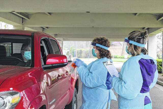 
			
				                                Daily Journal file photo
                                Medical workers conduct a COVID-19 test at a drive-thru testing site in 2020.
 
			
		