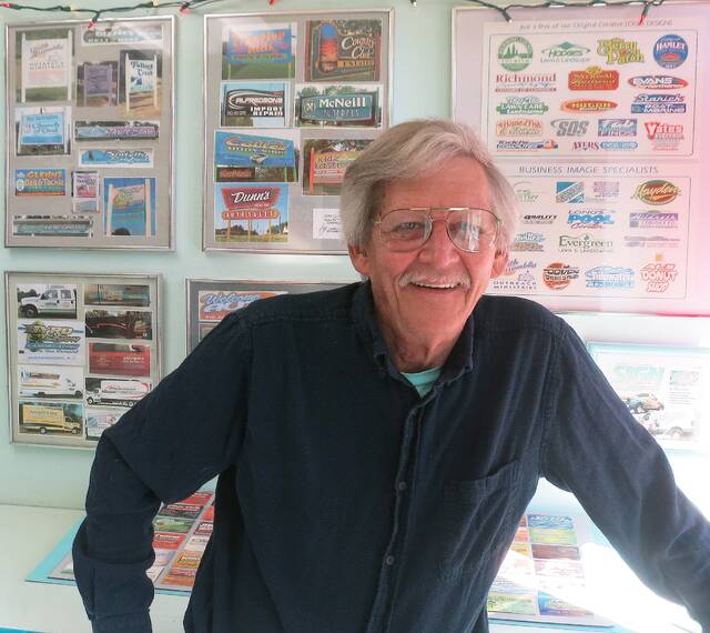 130215950_web1_Me-DEC-4-2019
Dean Dino Lawrence standing in front of a display of many of his hand-designed logos.
Photo courtesy of Carolina Signworks
