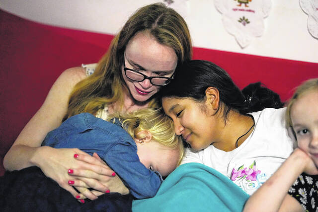 130242345_web1_130242345-eab47db202ba4046ac33fcfbfaa1c6e2
Sol, center, a 14-year-old from Argentina, snuggles up with her foster mother, Caroline Hazelton, and two of the Hazelton kids, Jessie, left, and Maddie, right, in Homestead, Fla., Monday, Dec. 18, 2023. Sol is among tens of thousands of children who have arrived in the United States without a parent during a huge surge in immigrants thats prompting congressional debate to change asylum laws.
Rebecca Blackwell | AP
